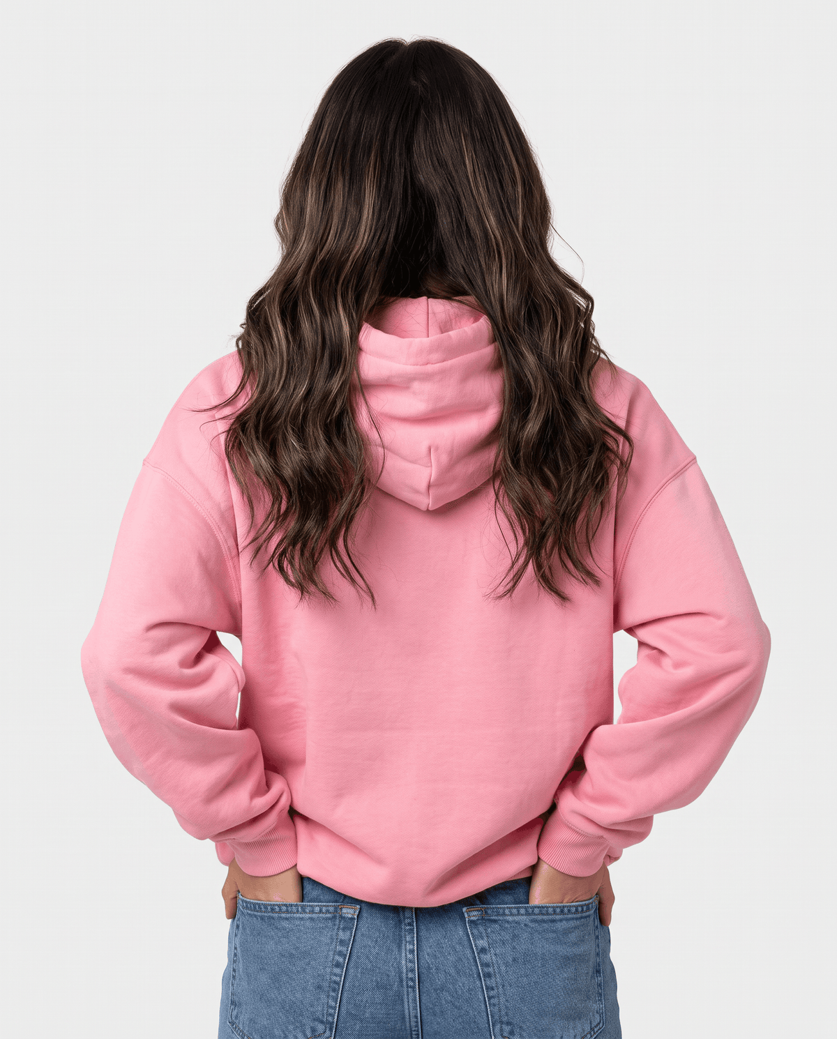 Back view of the pink loose-fit hoodie with the hood down over jeans