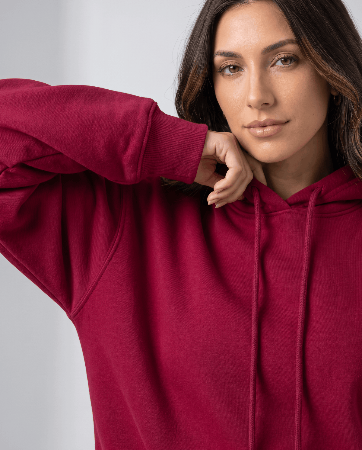Close-up of the red hoodie drawstrings and sleeve with a hand at the shoulder