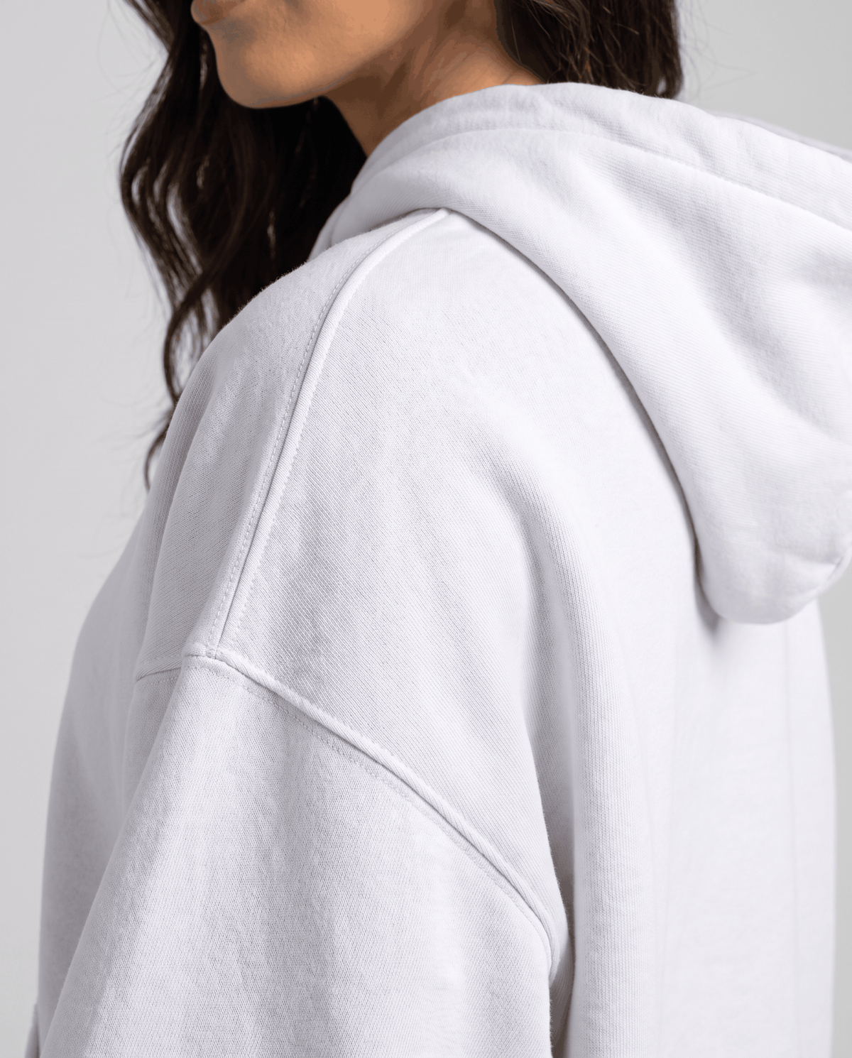Side close-up of the white hood and dropped shoulder seam on thick fabric