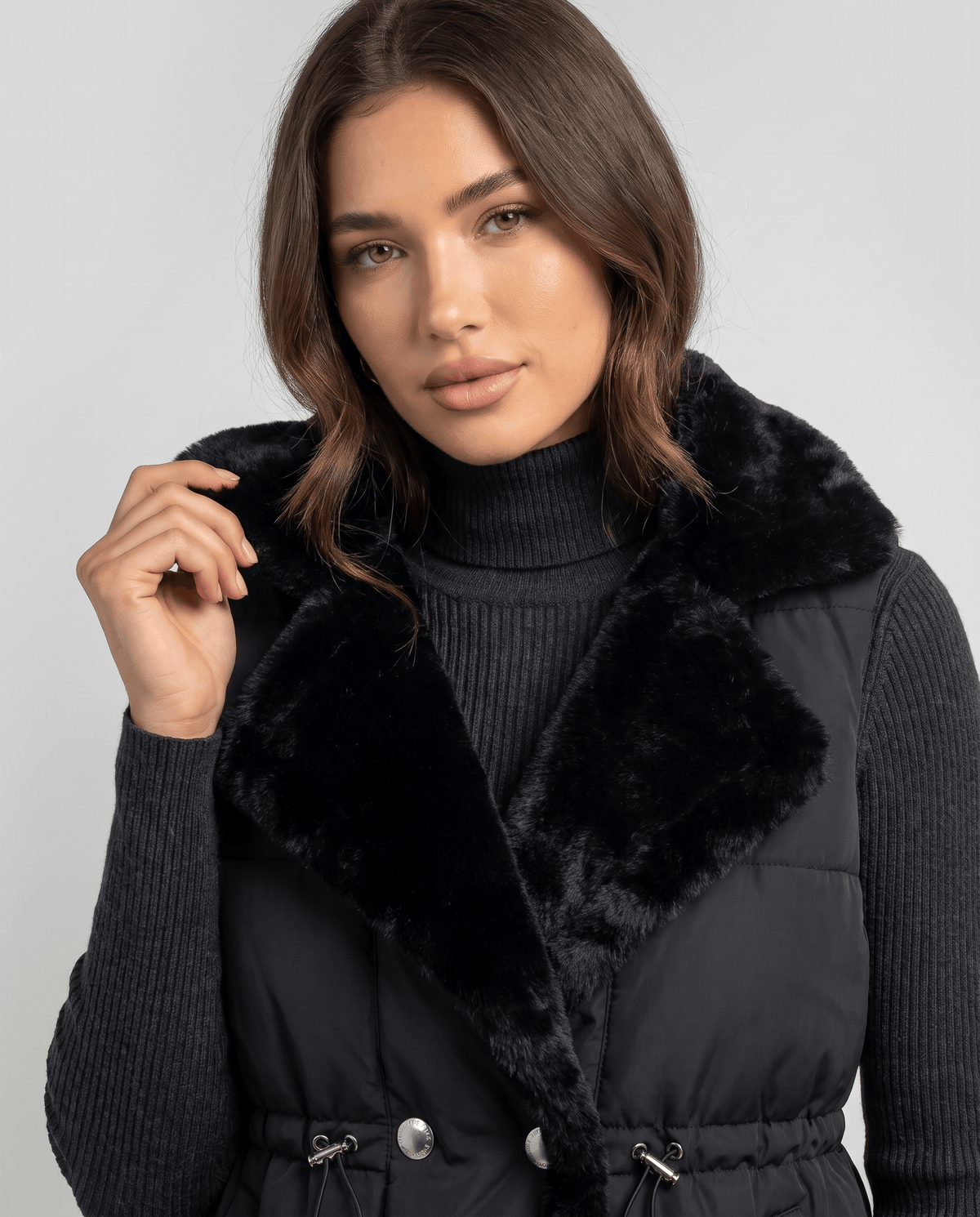 Black padded vest plush collar and drawstring waist shown up close
