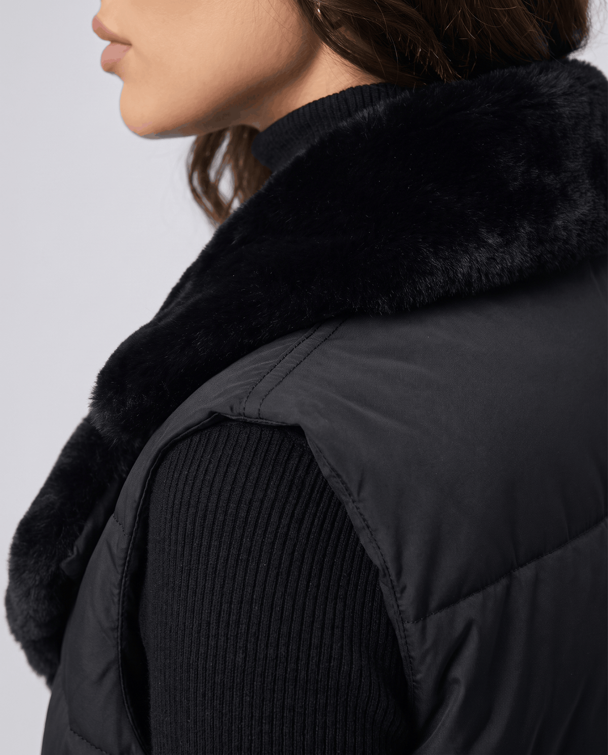 Side view of black padded vest plush collar and quilted body