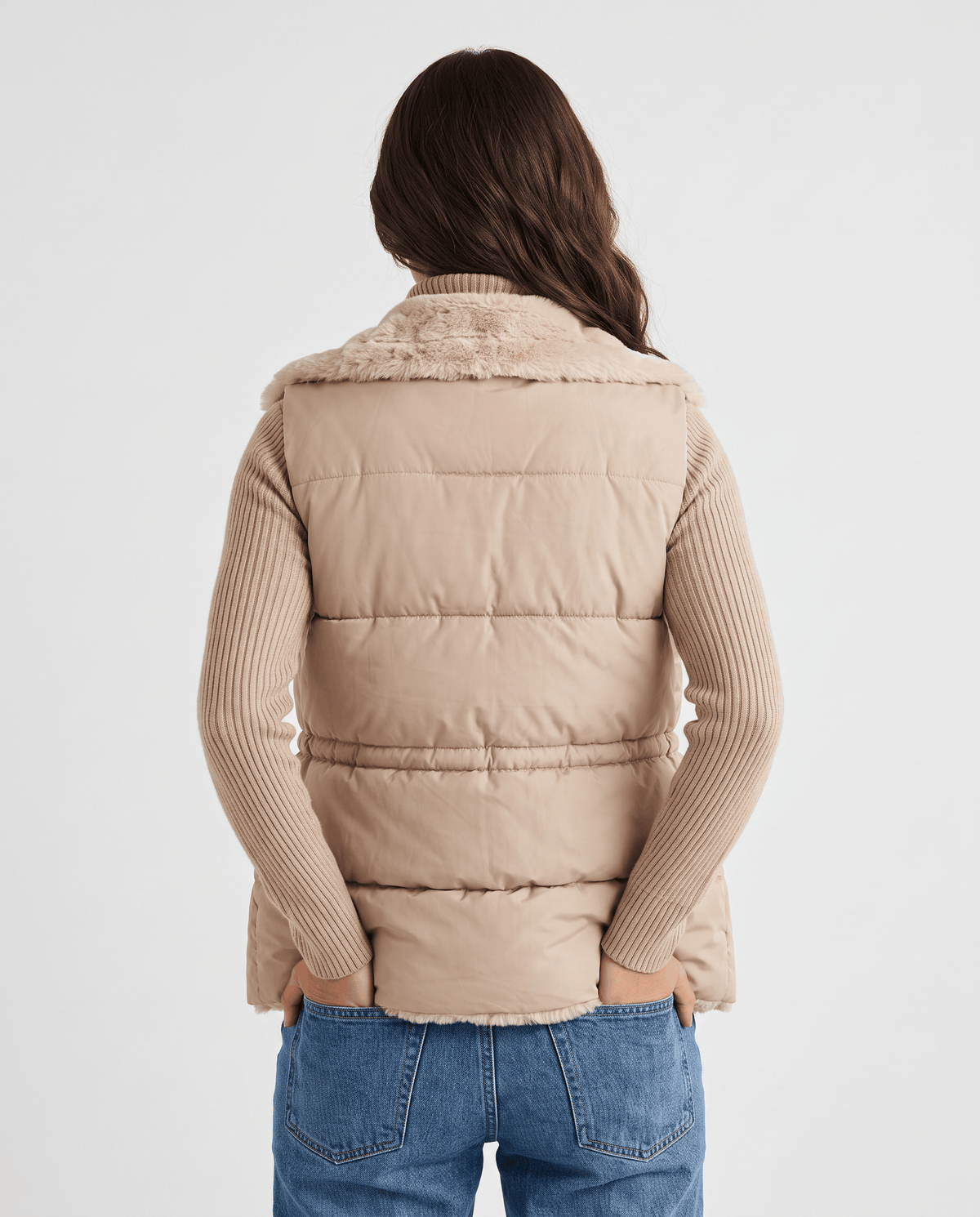 Back view of brown padded vest with horizontal quilting worn with jeans