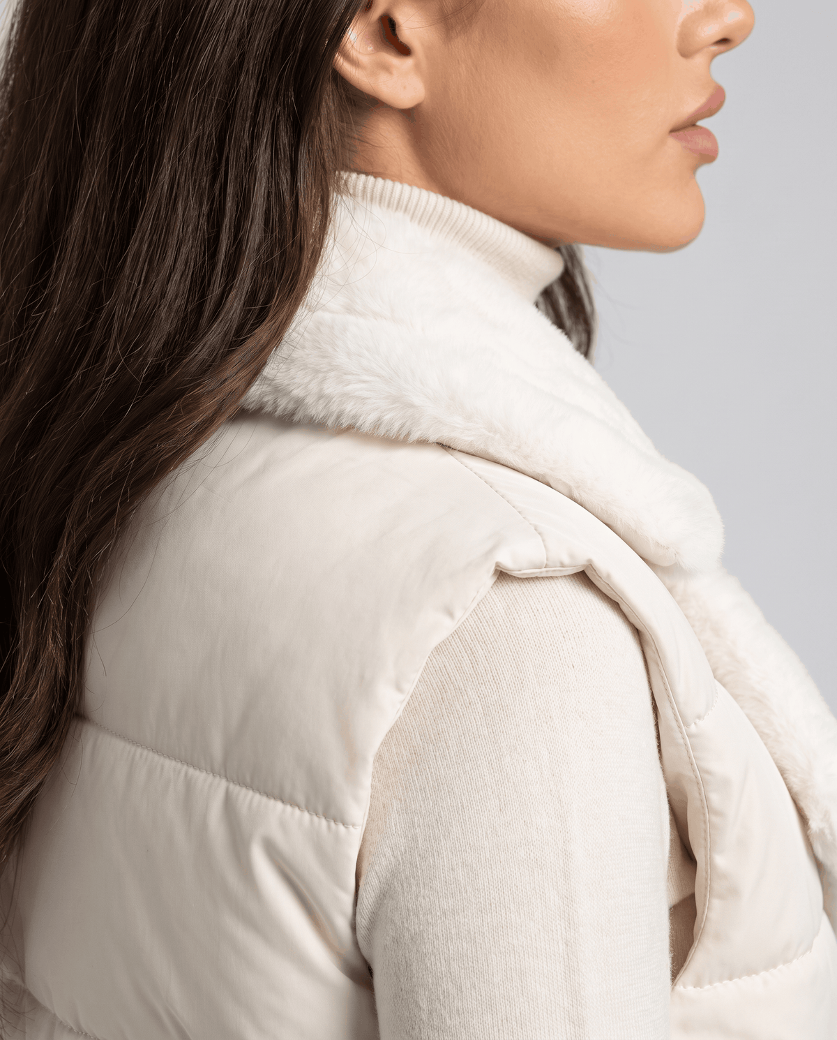 Side view of ivory padded vest plush collar and quilted body