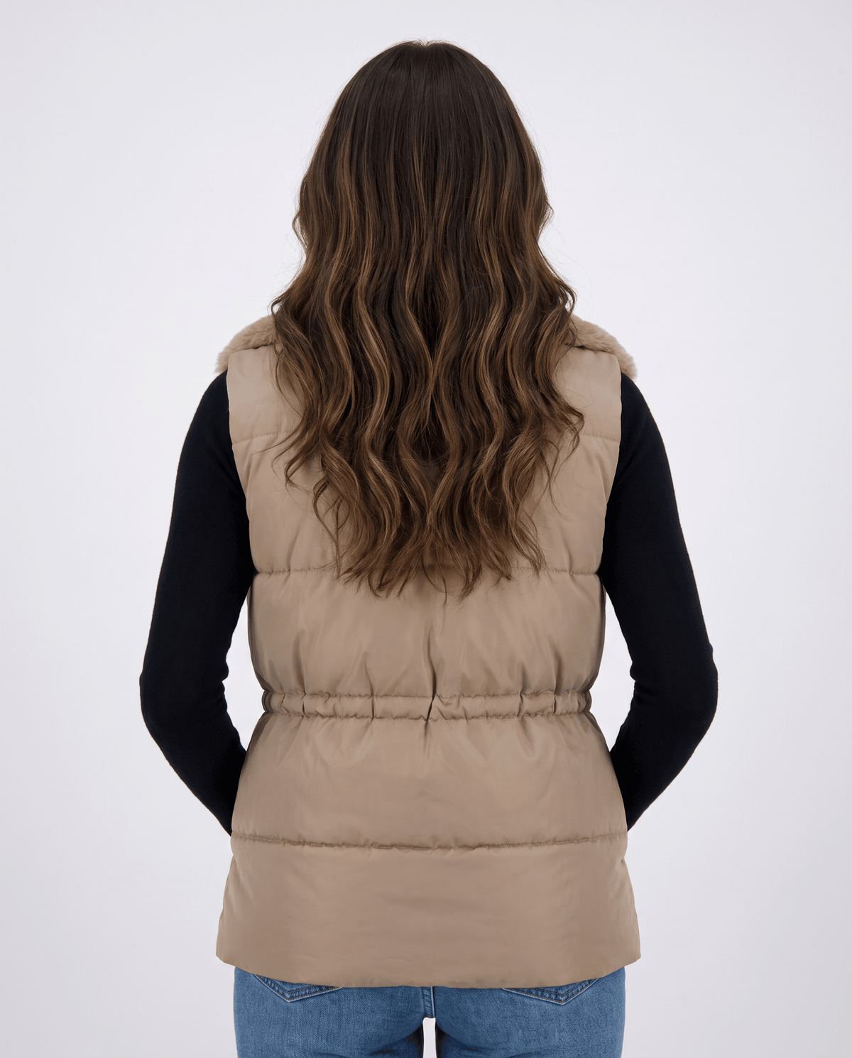 Back view of khaki padded sleeveless vest worn over a black top