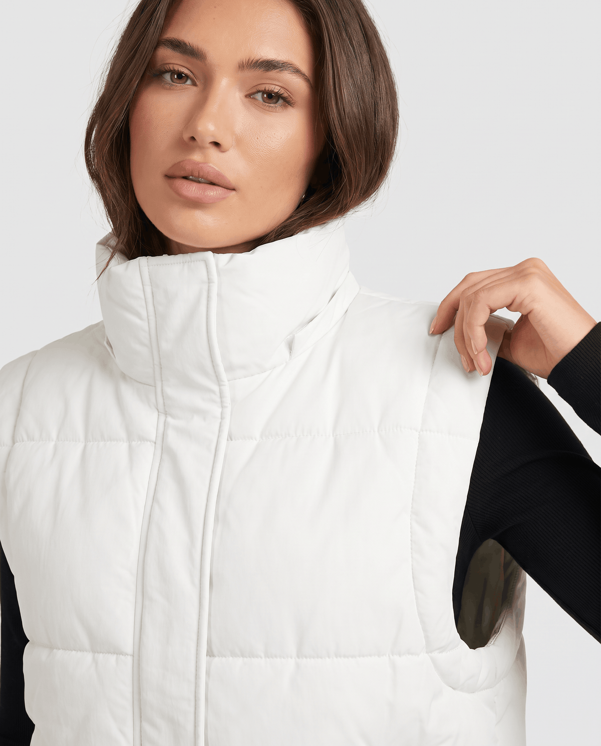 White padded vest raised collar and zip shown in close view