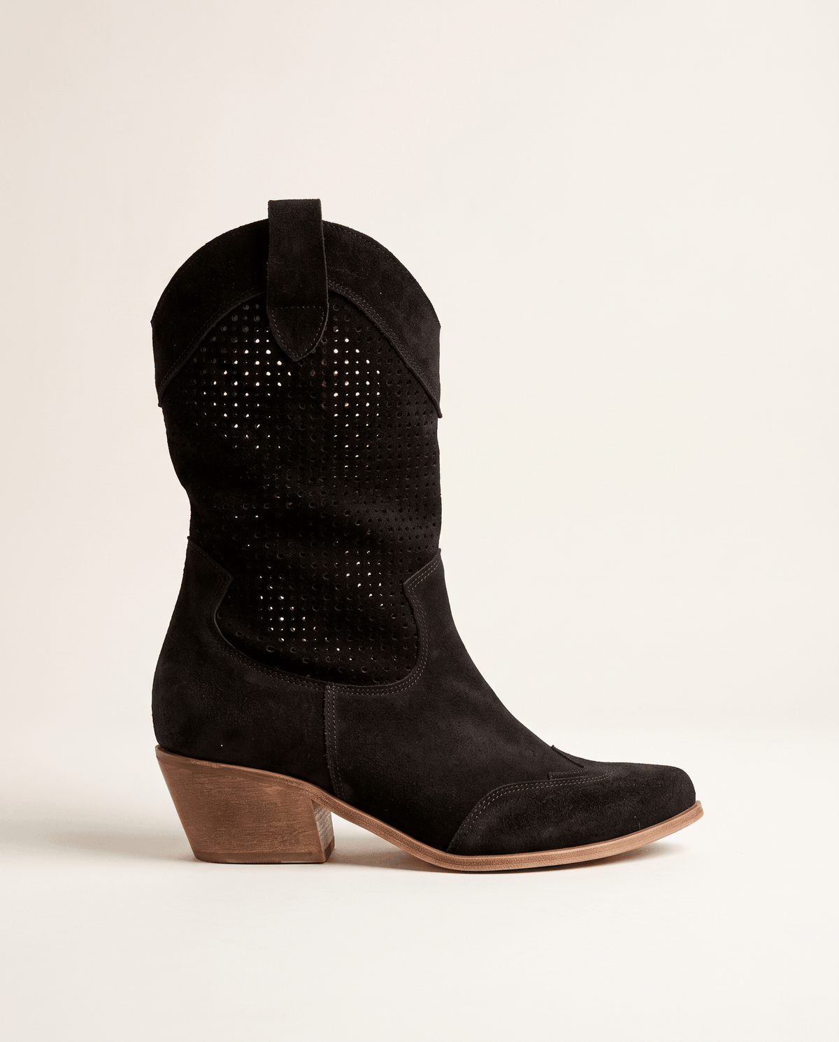 Single black cowboy boot in side profile showing perforated shaft and stacked heel