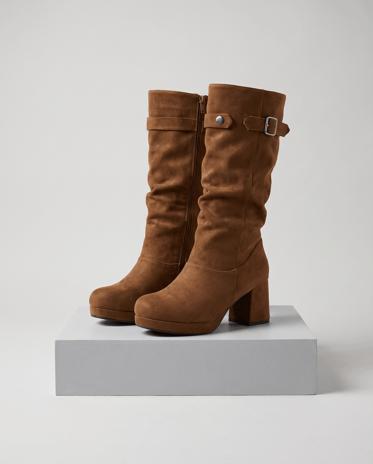 Brown pair on a white display block showing the rounded toe and buckle cuff