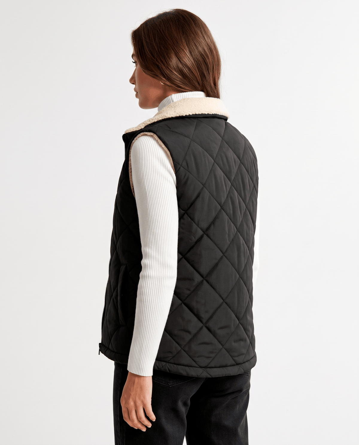 Side-back view of black quilted vest on a model