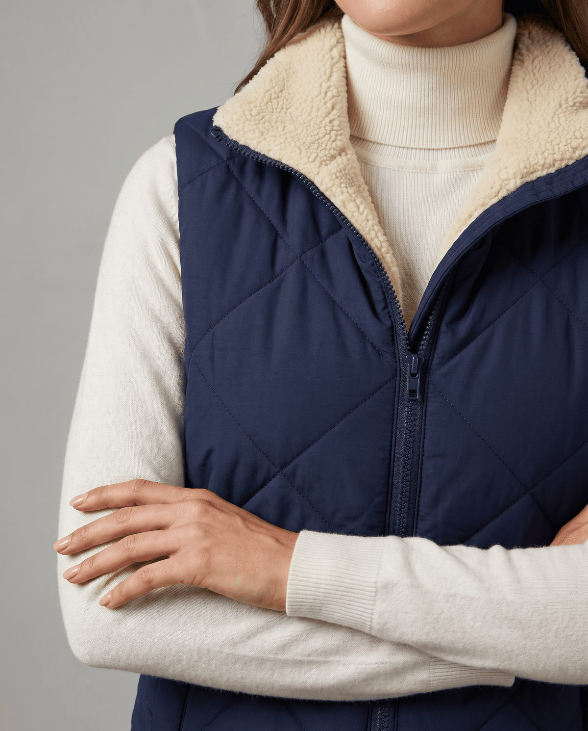Blue quilted vest zip front and cream sherpa lining shown in close view