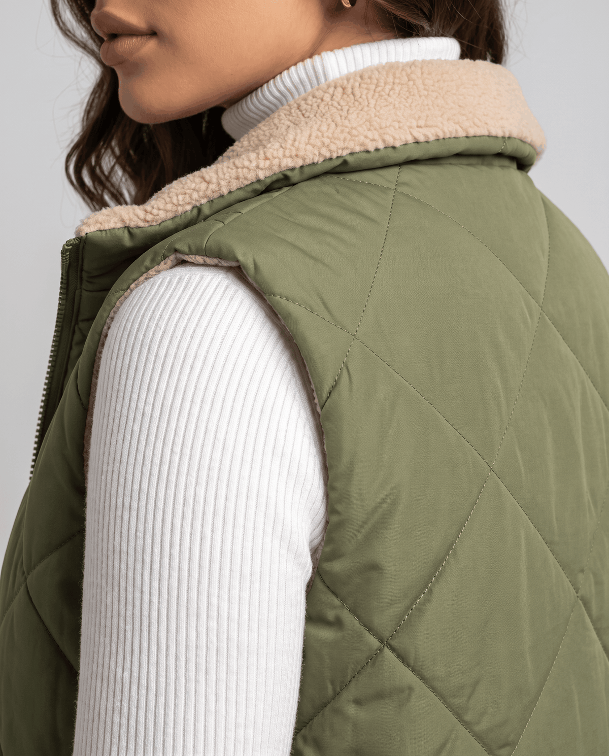Green quilted vest side detail showing the stand collar and quilting