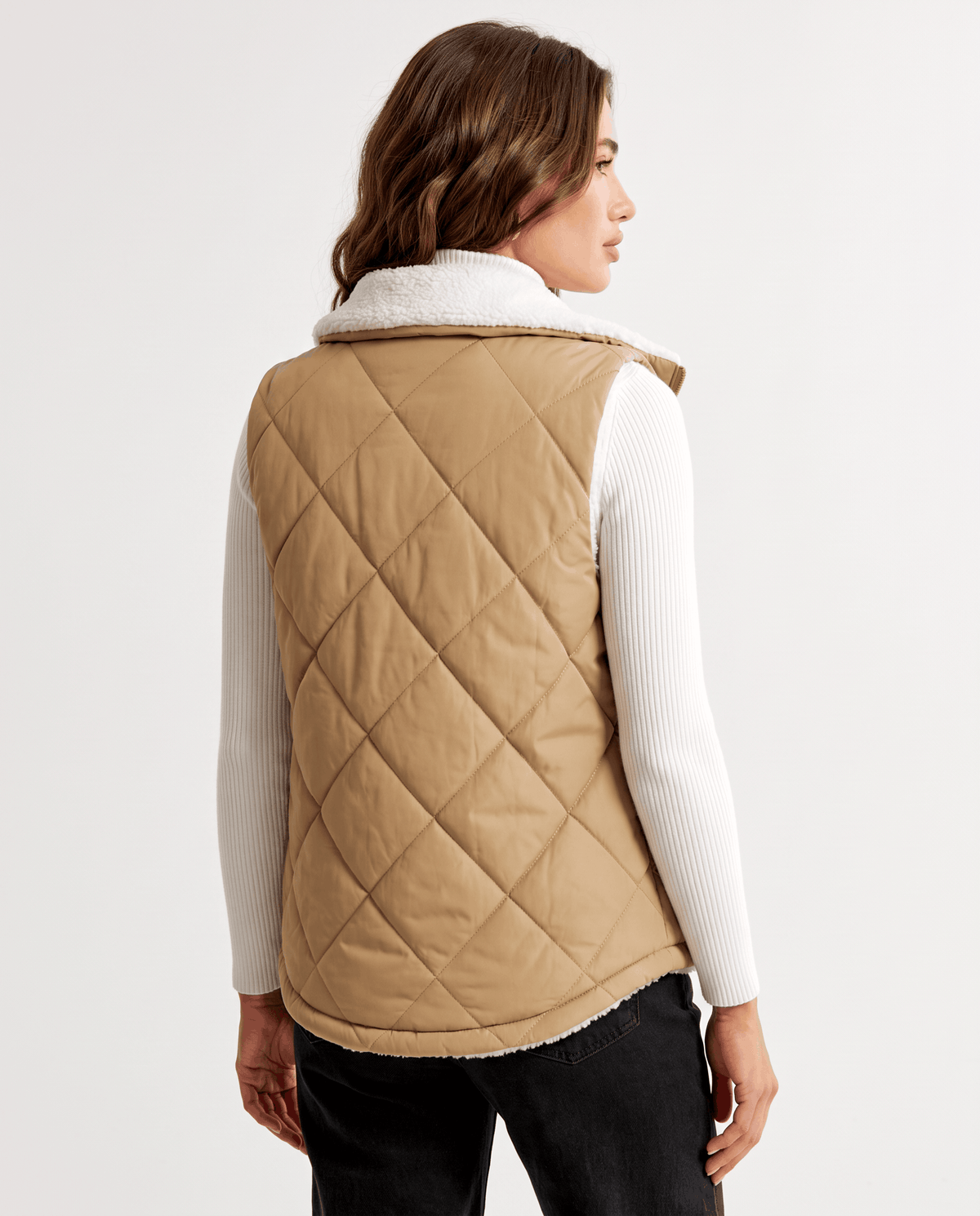 Back view of khaki diamond-quilted vest with a curved hem