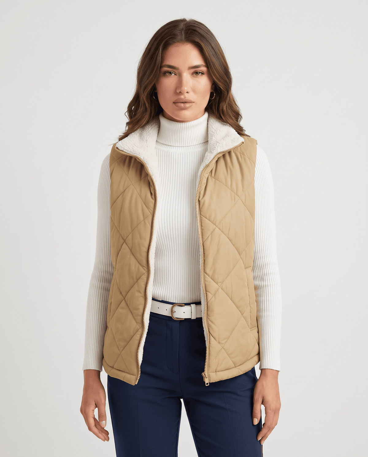 Khaki diamond-quilted vest with white turtleneck and navy trousers, front view