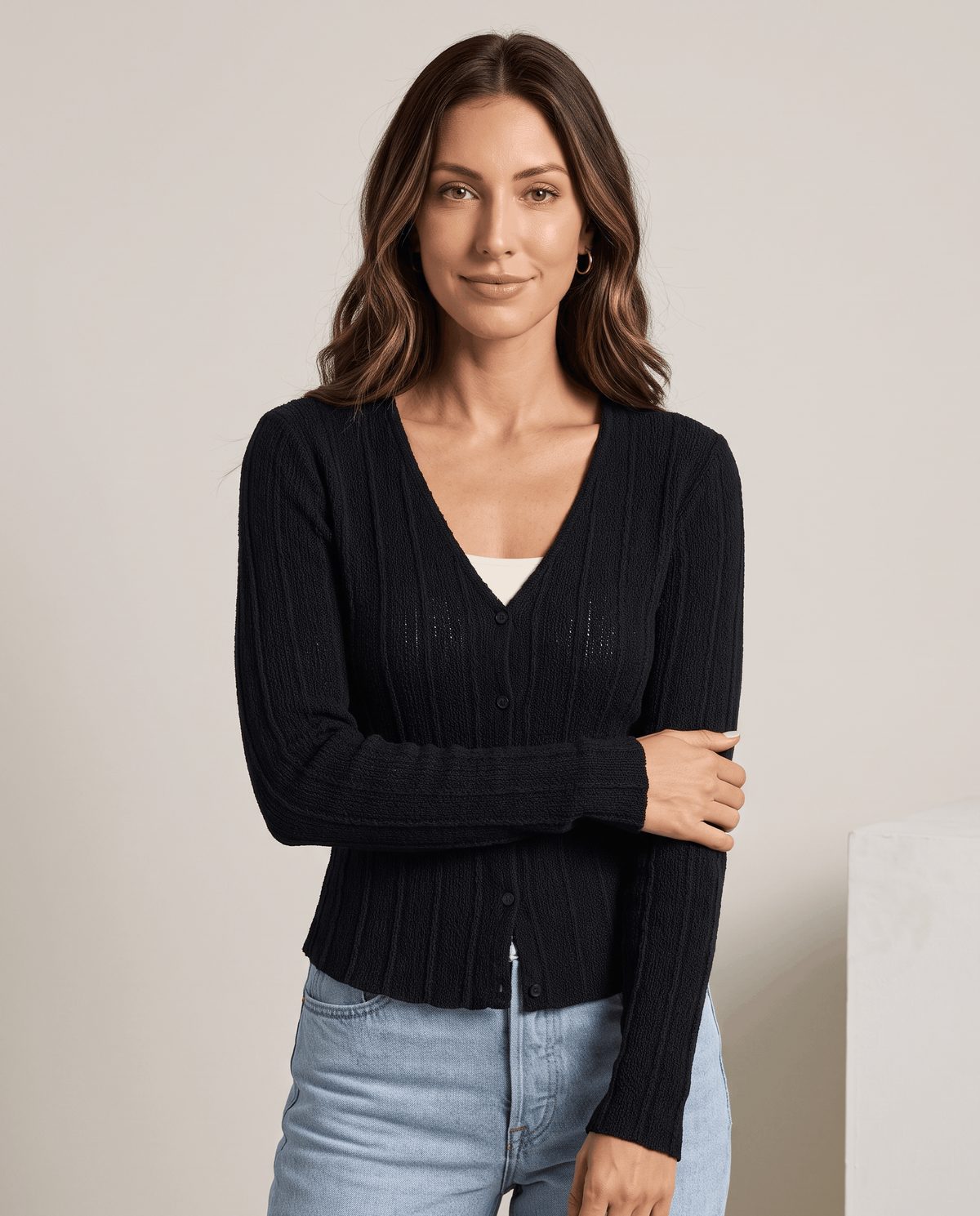 Women's black ribbed V-neck cardigan with button front worn with light blue jeans