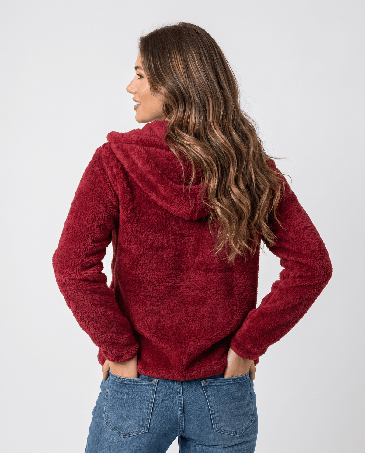 Back of burgundy sherpa hoodie with the hood down and hands in pockets
