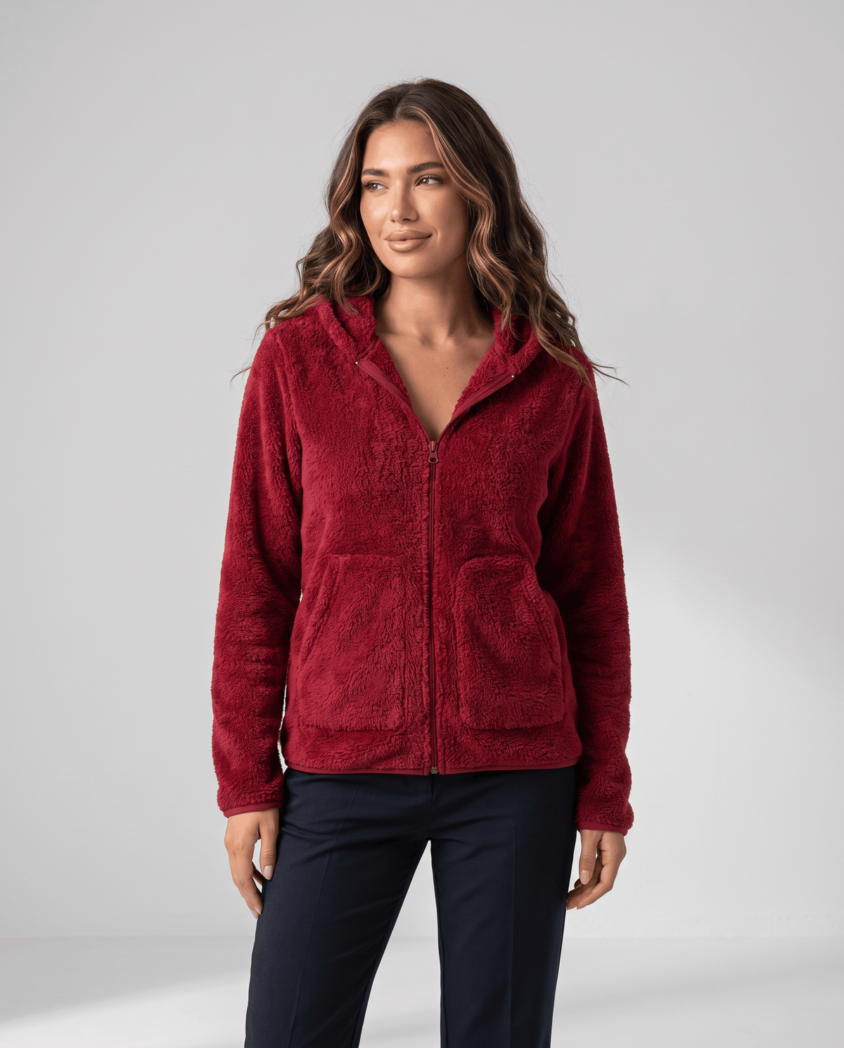 Front view of burgundy sherpa zip hoodie worn with dark pants and the zip closed