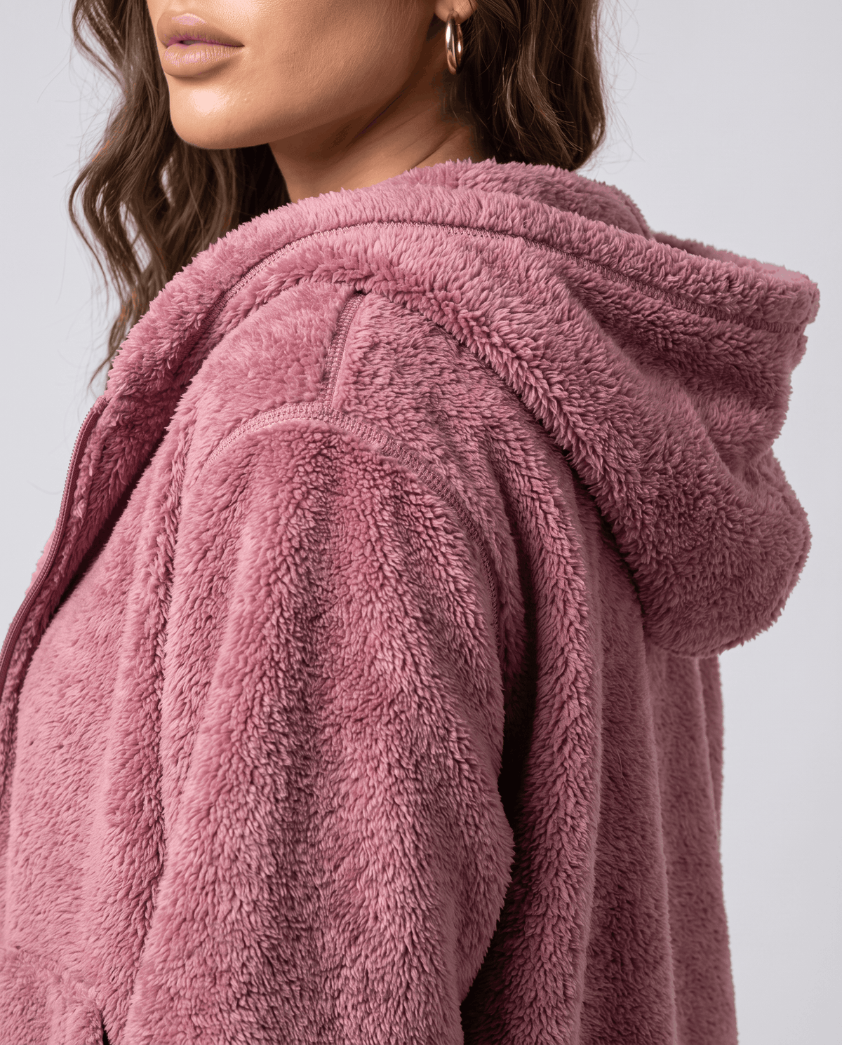 Close-up of dusty pink sherpa hood from the side with soft plush pile