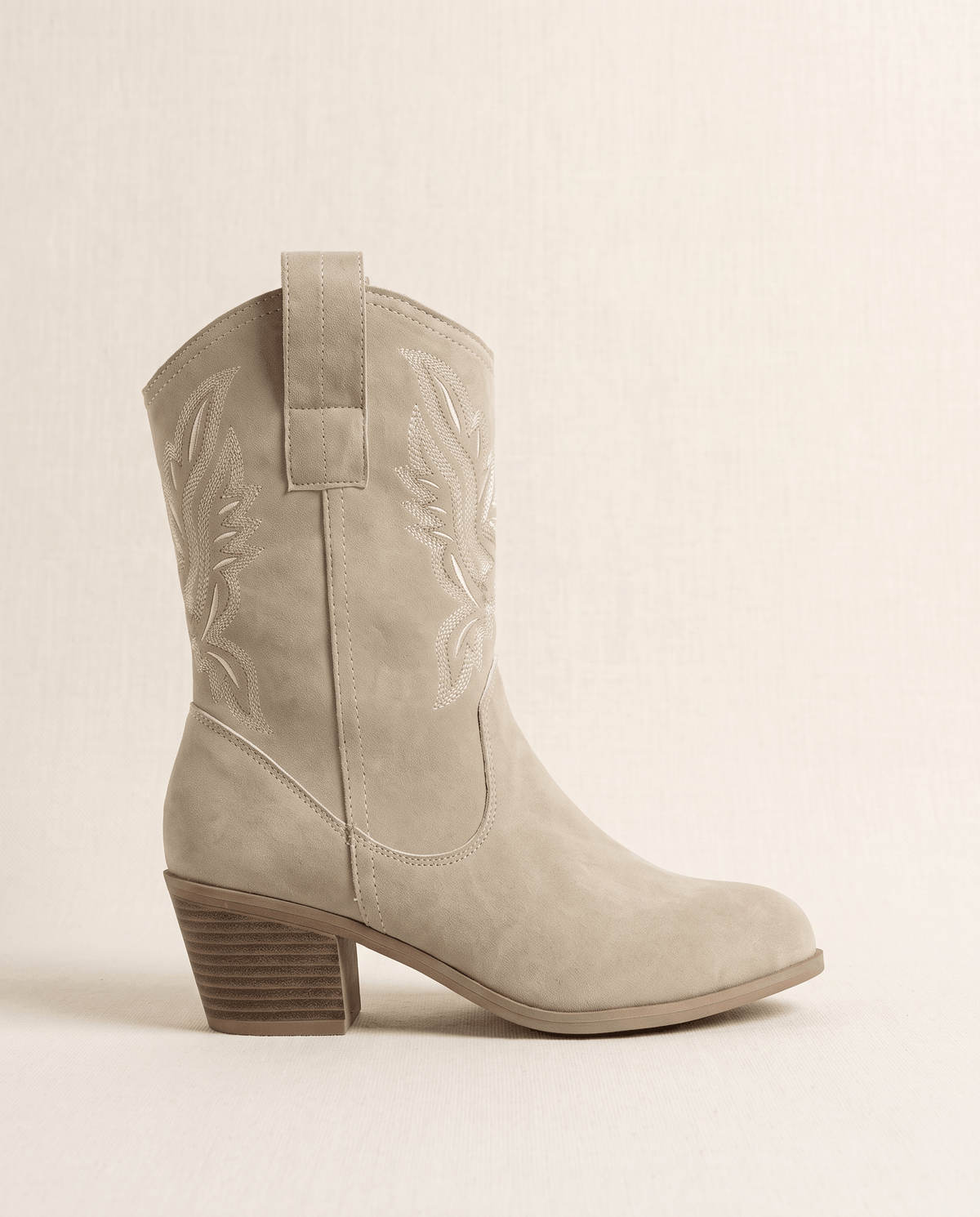 Single beige short western boot in side profile against a cream backdrop