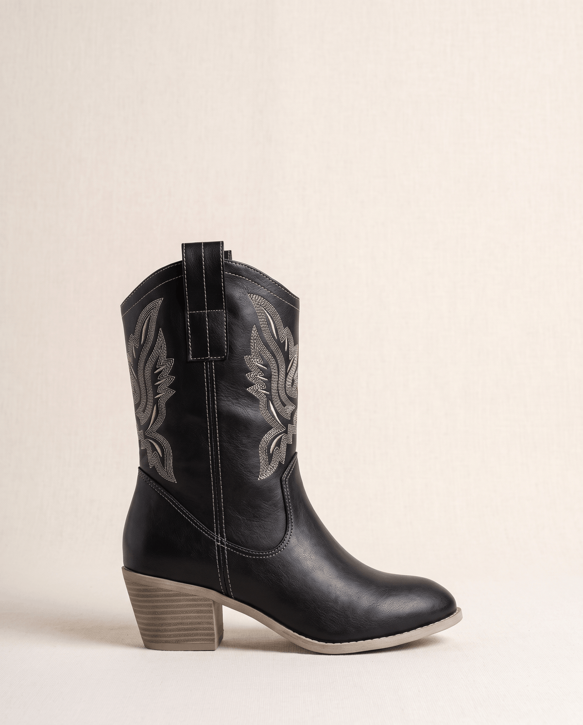 Single black boot in side profile showing contrast stitching and stacked heel