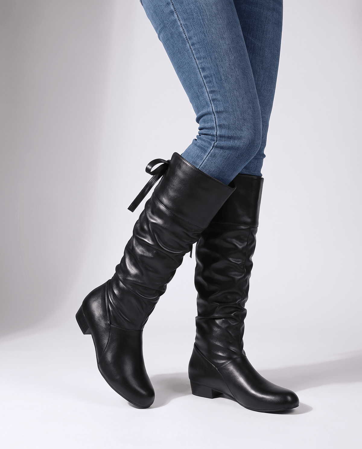 Woman in skinny jeans wearing black boots with the inside zip visible