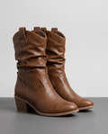 Pair of brown slouchy mid-calf cowboy boots with pull tabs and stacked heels