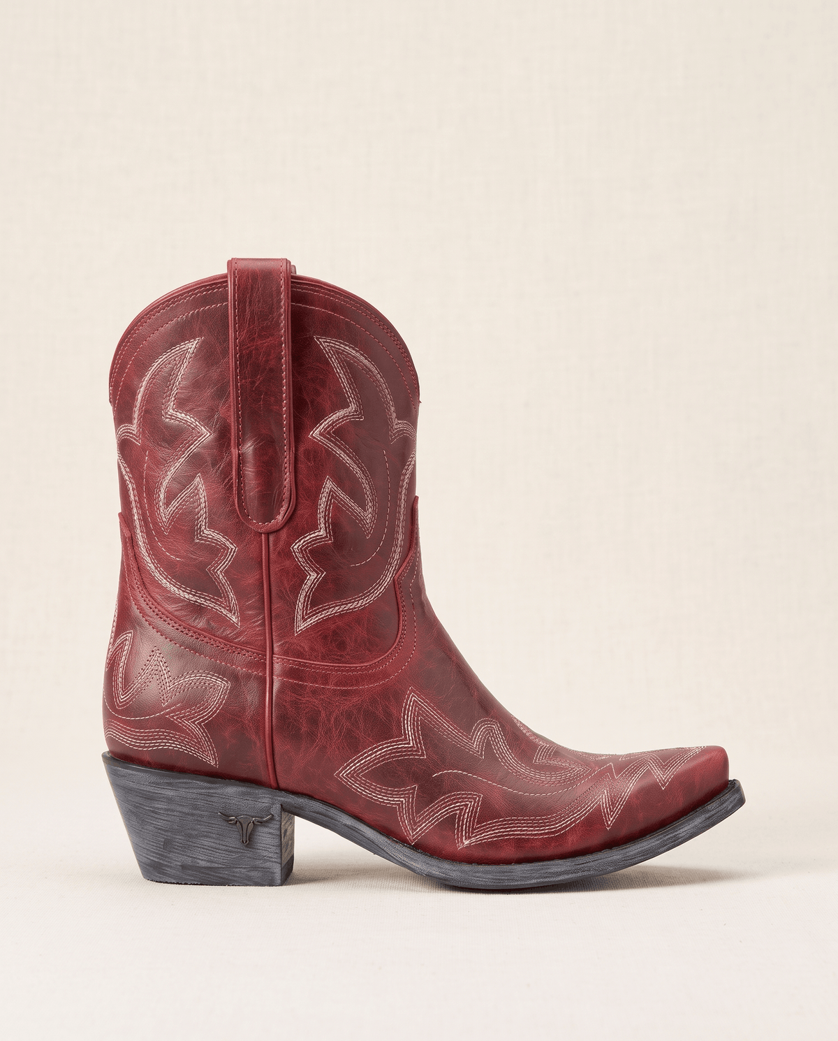 Single red boot in side profile showing tonal embroidery and snip toe