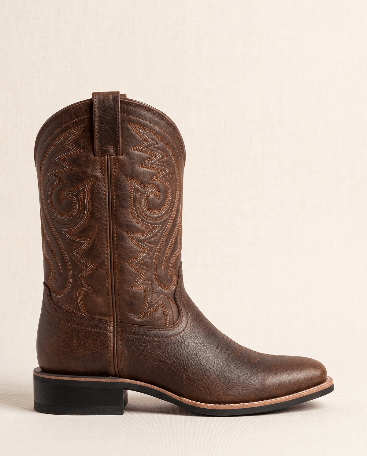 Single brown cowboy boot in side profile showing the square toe and low heel