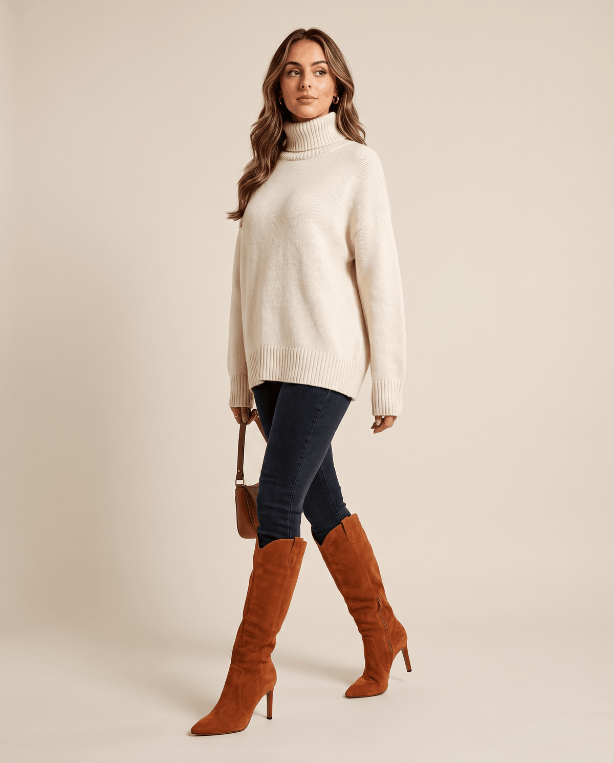 Camel suede knee-high boots with a pointed toe, slim stiletto heel, and close-fit shaft worn with dark denim jeans.
