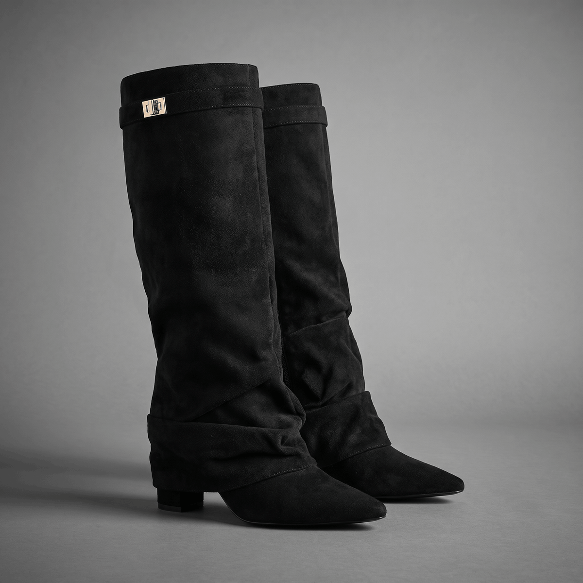 Black suede fold-over knee-high boots with a pointed toe and low block heels.