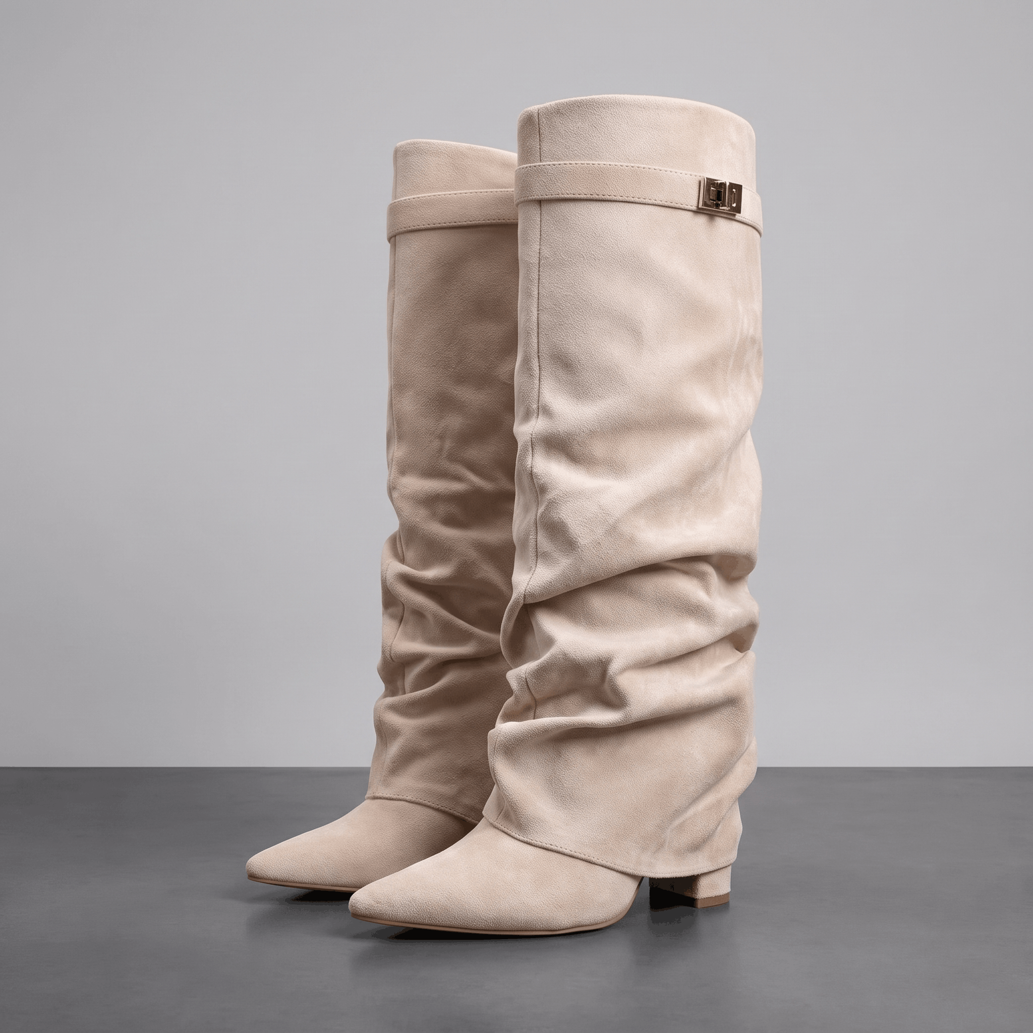 Beige suede fold-over knee-high boots with pointed toes and low block heels.