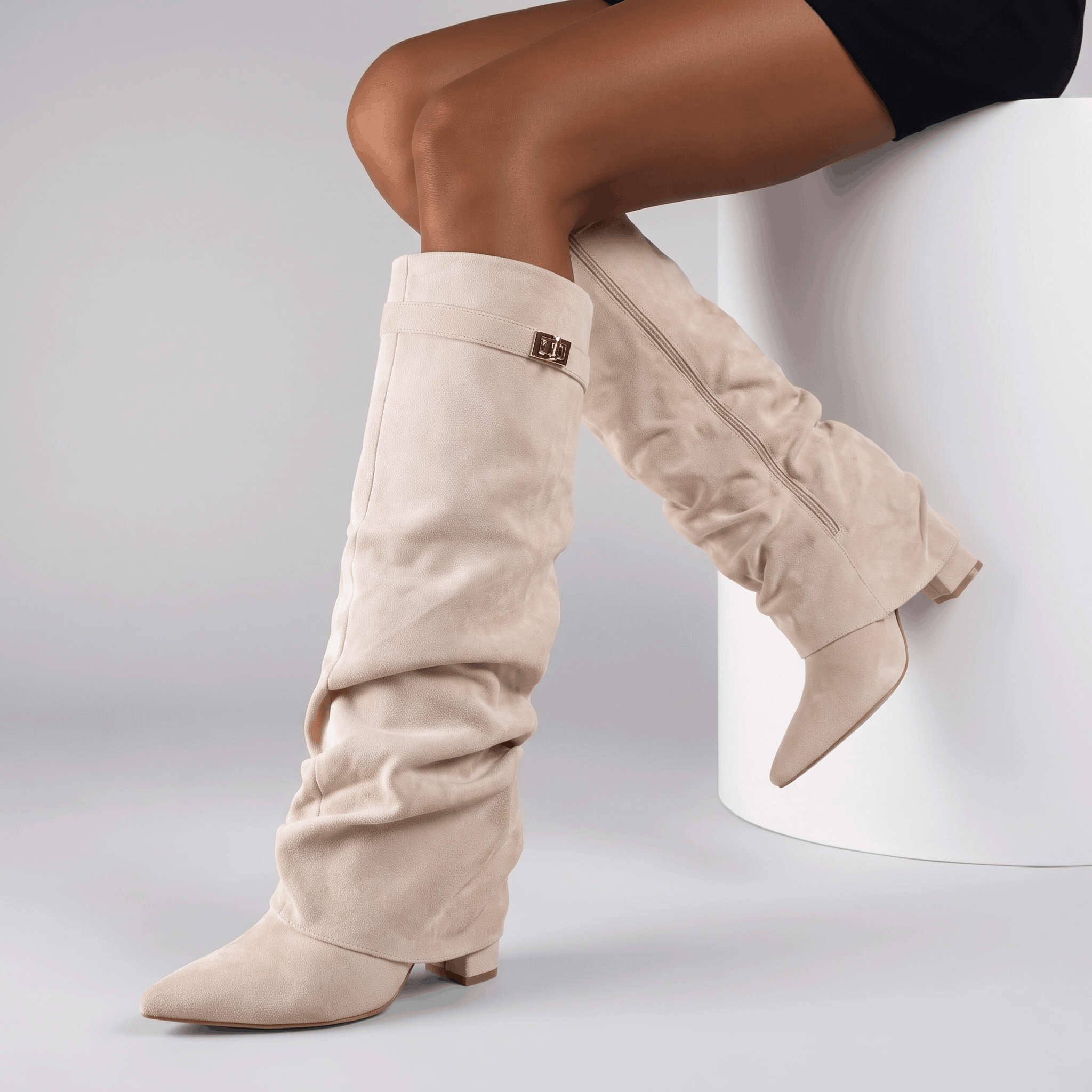Woman wearing beige suede fold-over knee-high boots with a short white dress.