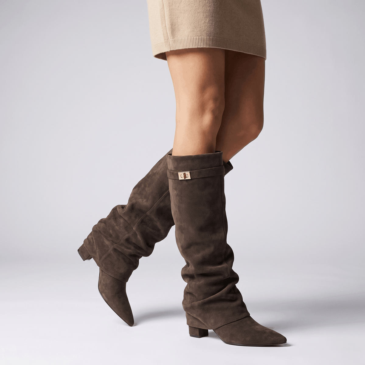Woman wearing dark brown suede fold-over knee-high boots with a short skirt.