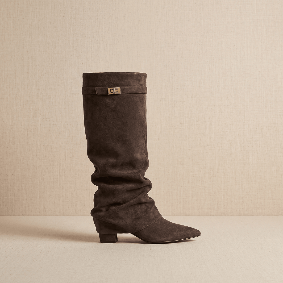 Dark brown suede fold-over knee-high boot with a pointed toe, side zip and low block heel.