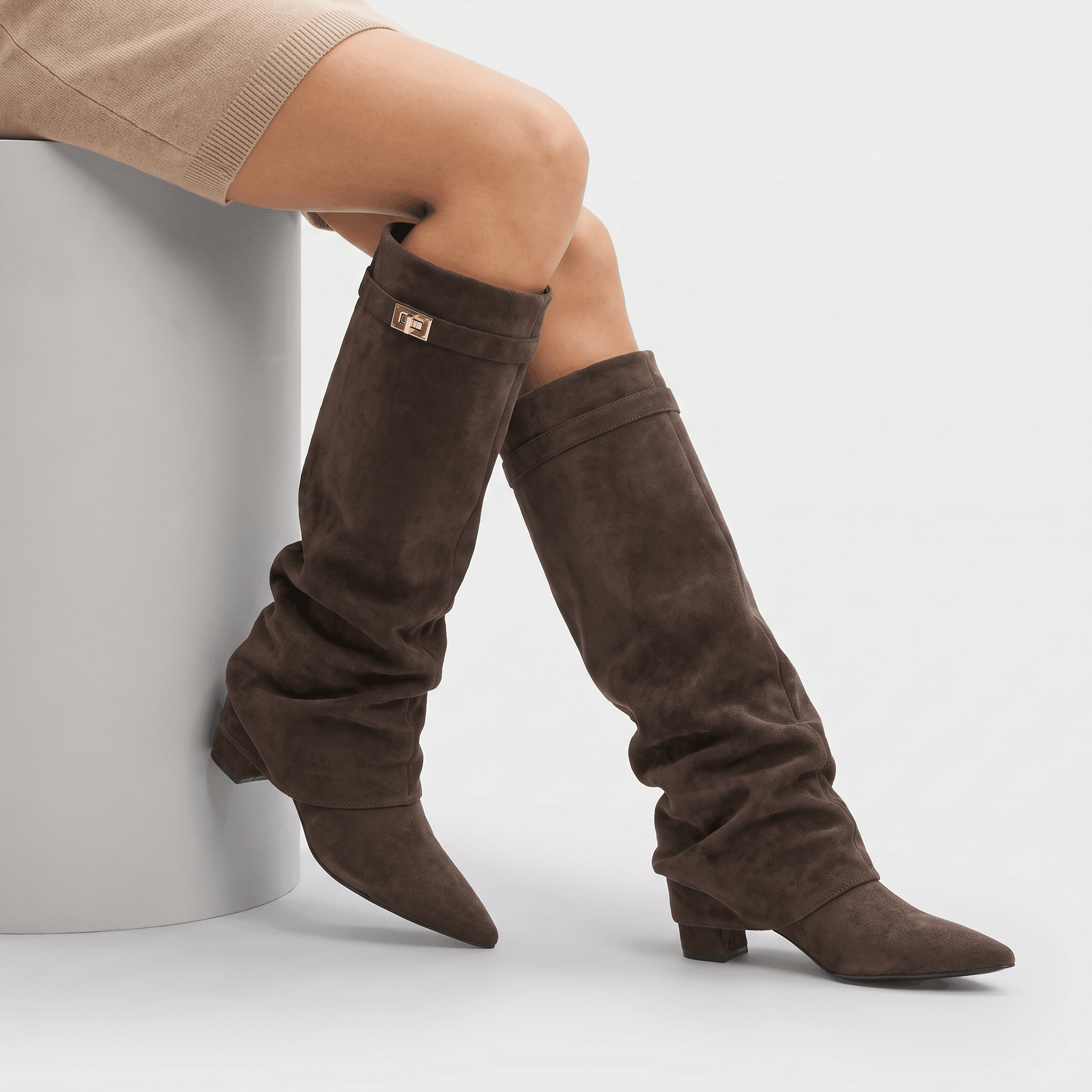 Pair of dark brown suede fold-over knee-high boots with pointed toes and low block heels.