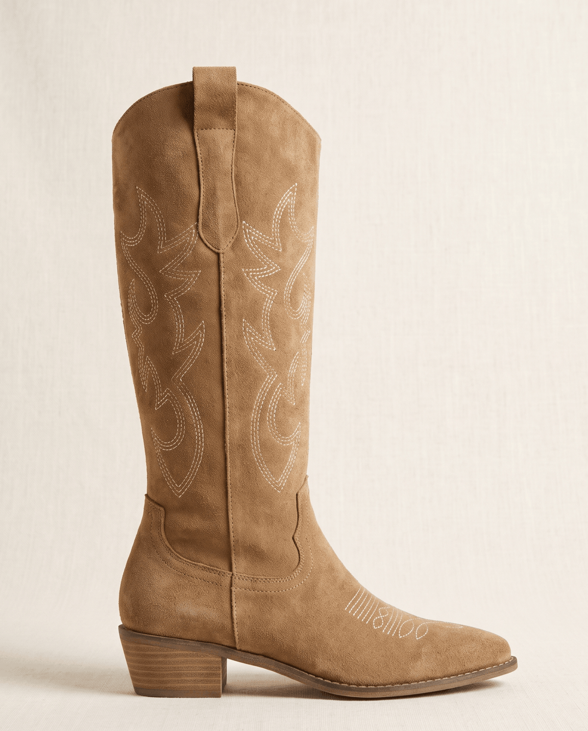 Single brown cowboy boot in side profile showing scroll stitching and pull tab