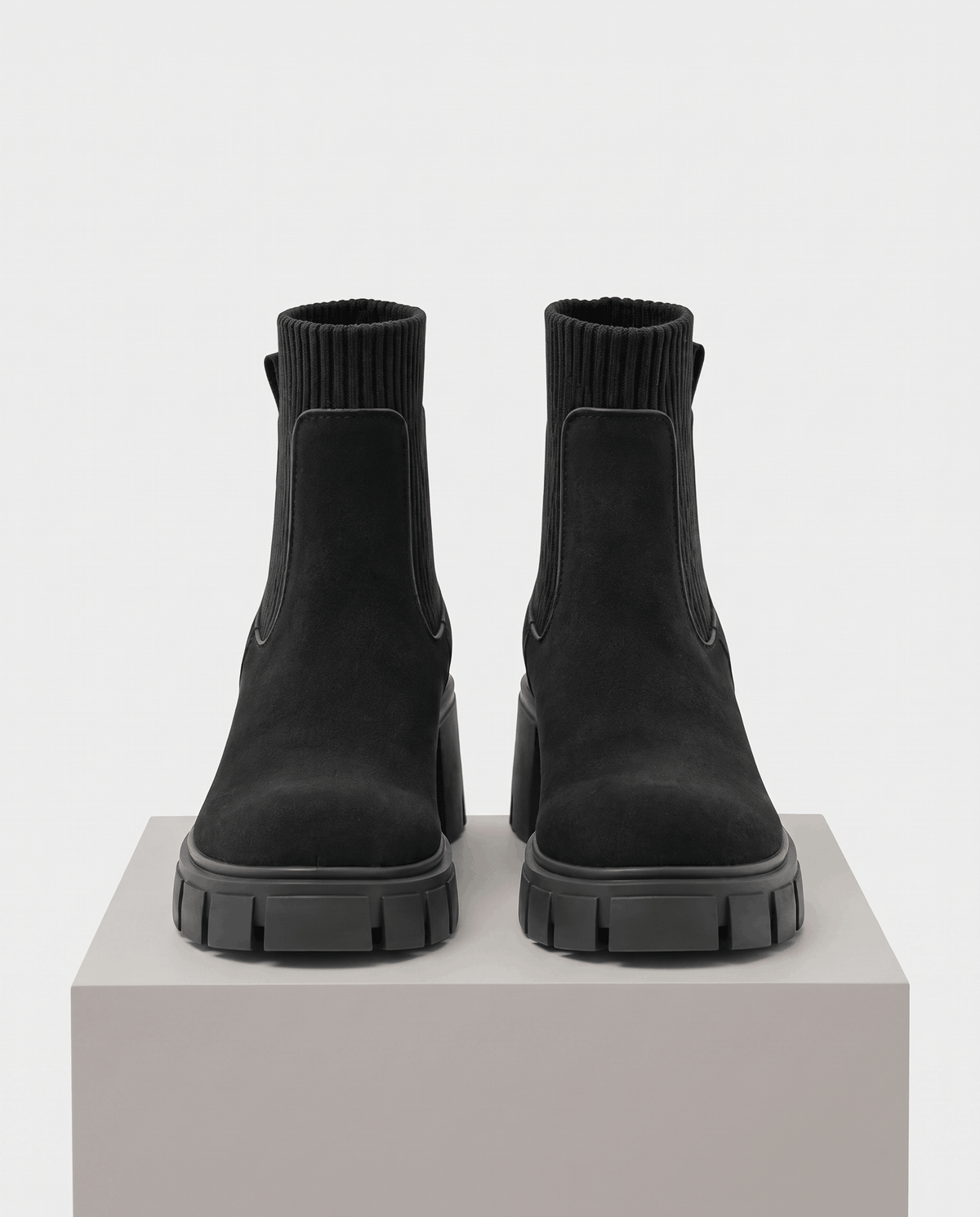 Front view of black suede boots on a pedestal showing the round toe