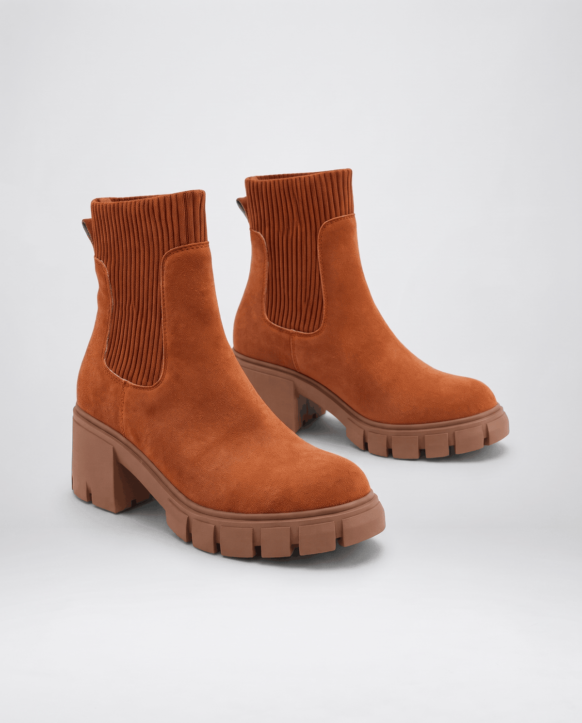 Brown suede boots angled to show the block heel and sole