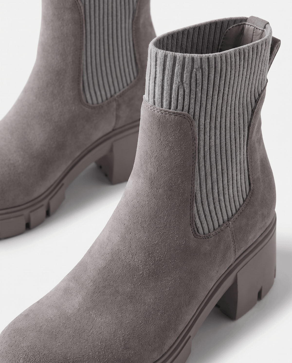 Close-up of gray ribbed elastic panel on a suede boot