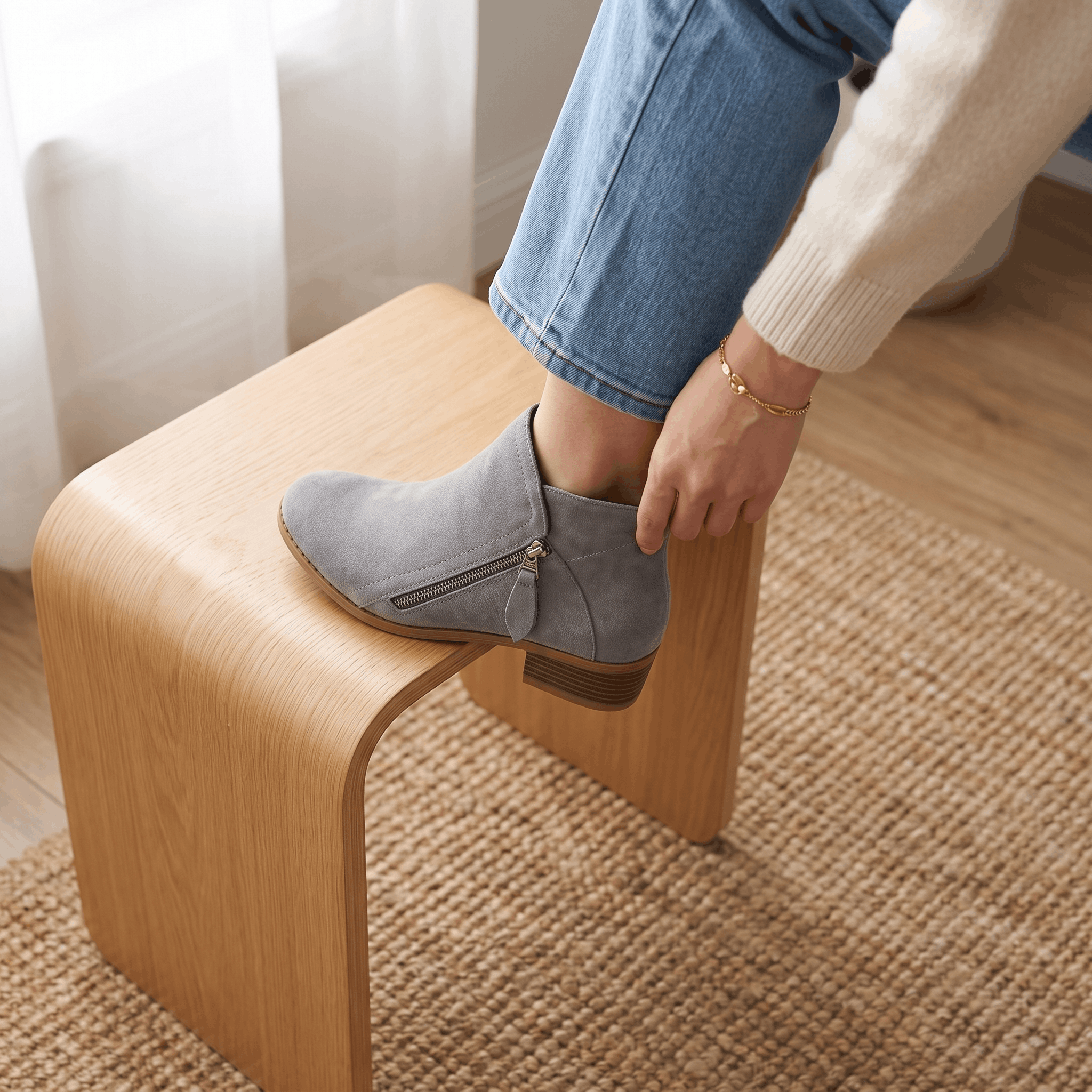 Close-up of gray suede ankle boots being worn indoors.