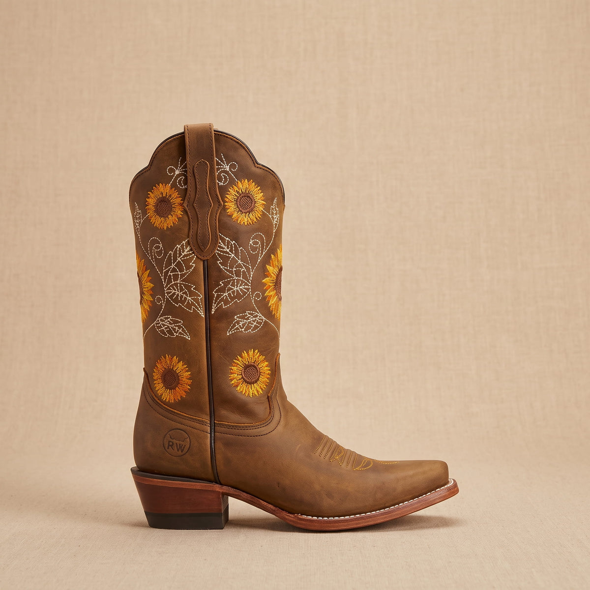 Single brown boot in side profile showing sunflowers and the stacked heel