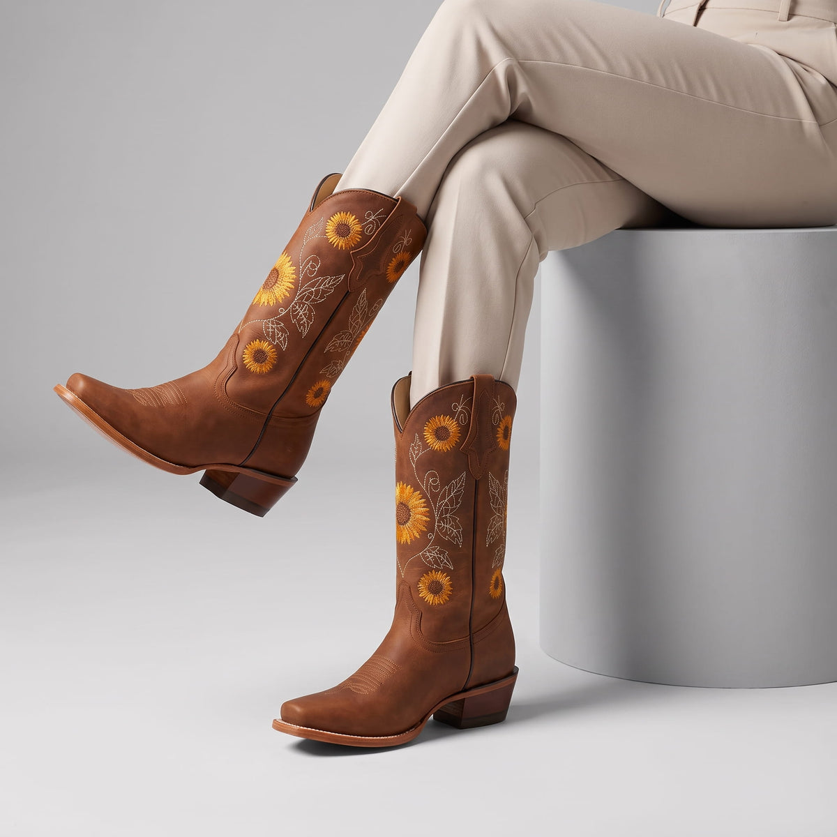Seated woman in cream trousers wearing brown sunflower boots