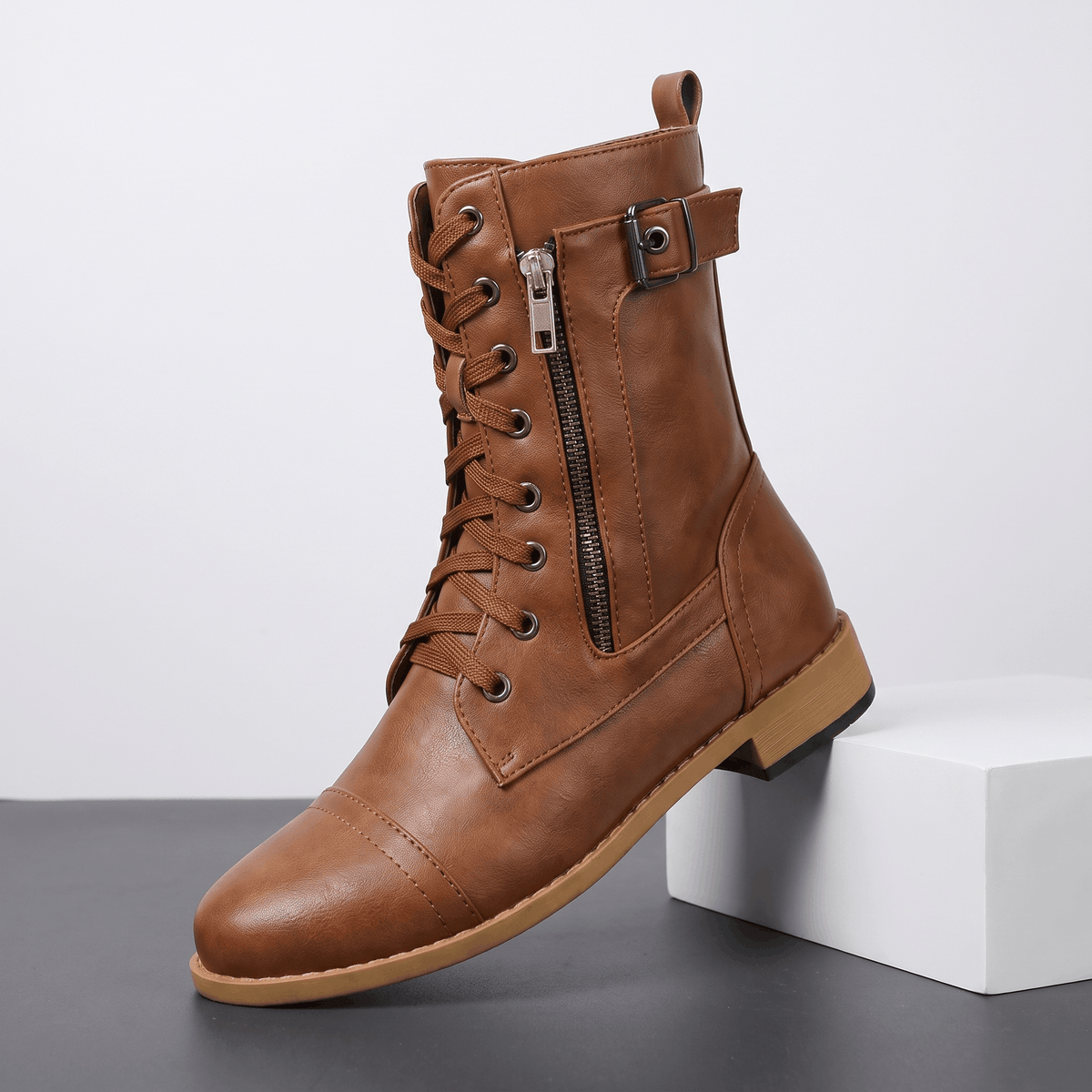 Brown vegan leather lace-up combat boots with side zipper and buckle details.