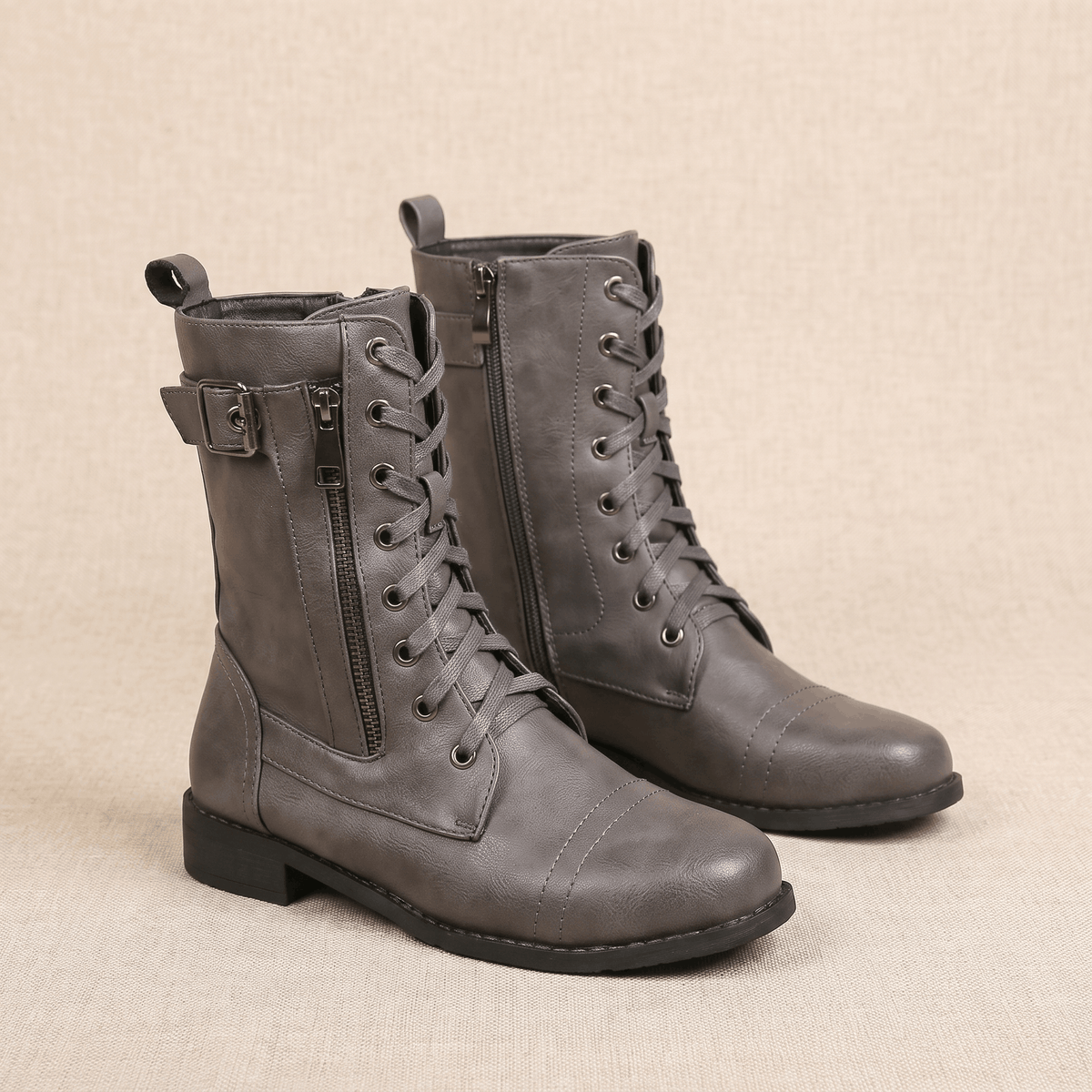 Pair of gray vegan leather lace-up combat boots with side zippers.