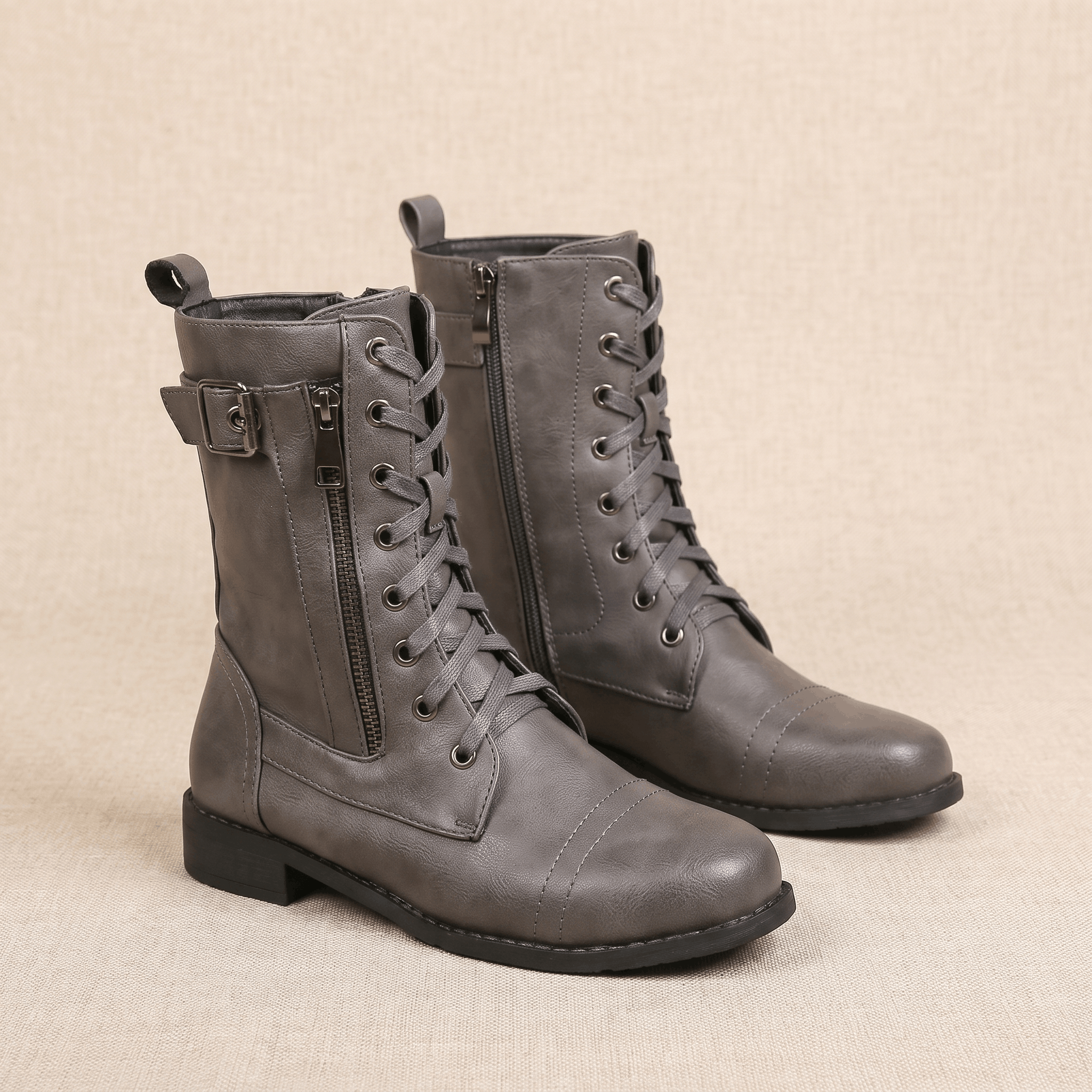 Pair of gray vegan leather lace-up combat boots with side zippers.