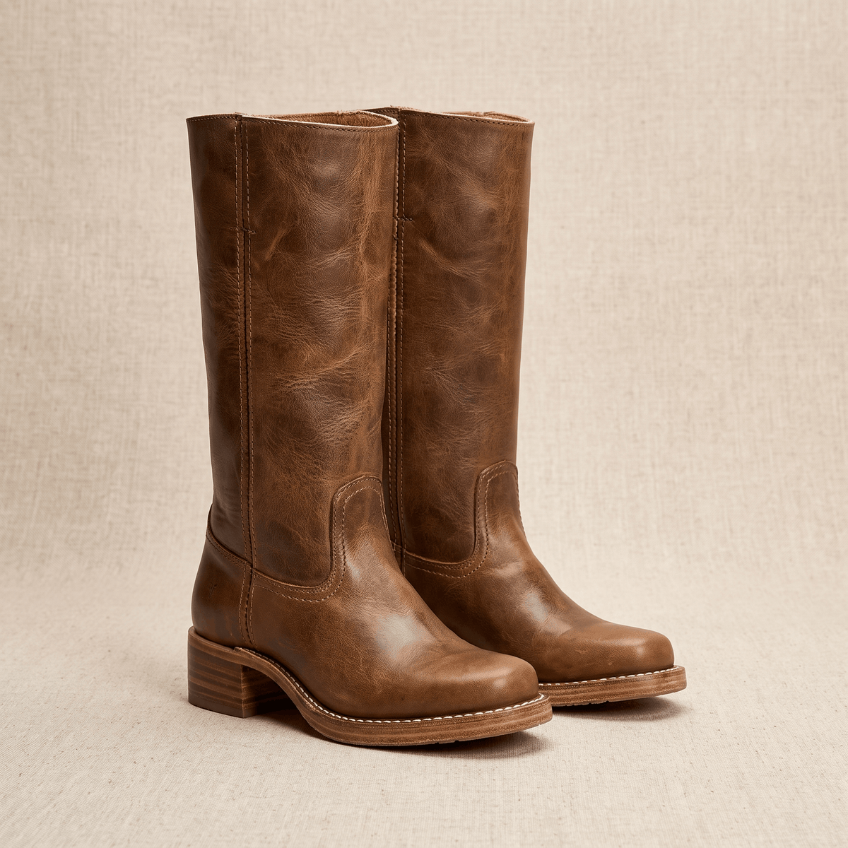 Brown vegan leather knee-high riding boots with a stacked block heel.