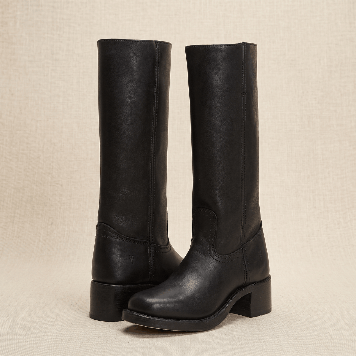 Pair of black vegan leather knee-high riding boots with block heels.