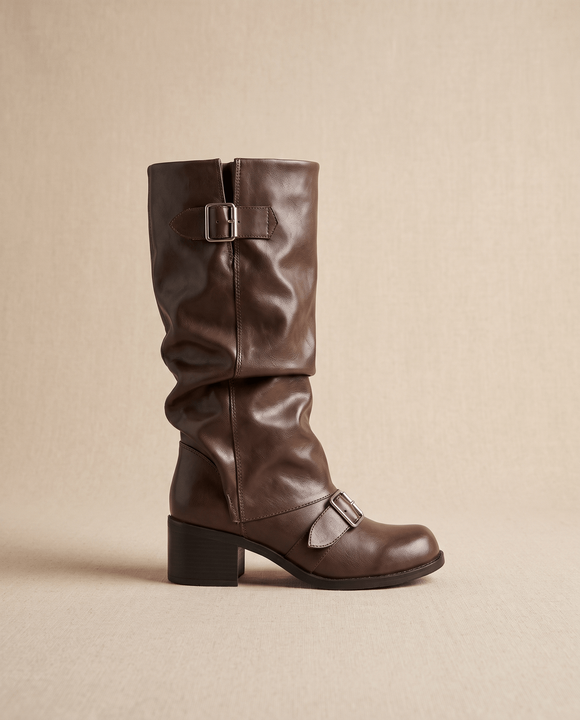 Brown vegan leather mid-calf boots with a ruched slouch shaft, double buckle straps, and a stacked block heel.