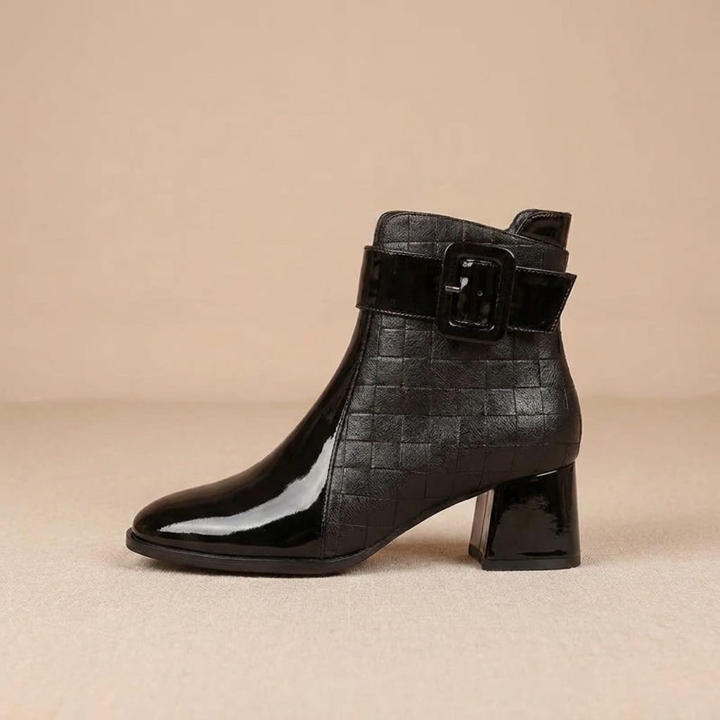 Single black vegan leather ankle boot with two-tone textured panels and a block heel.