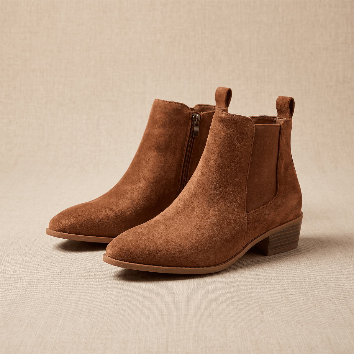 Pair of brown vegan suede Chelsea boots shown on a neutral beige background.