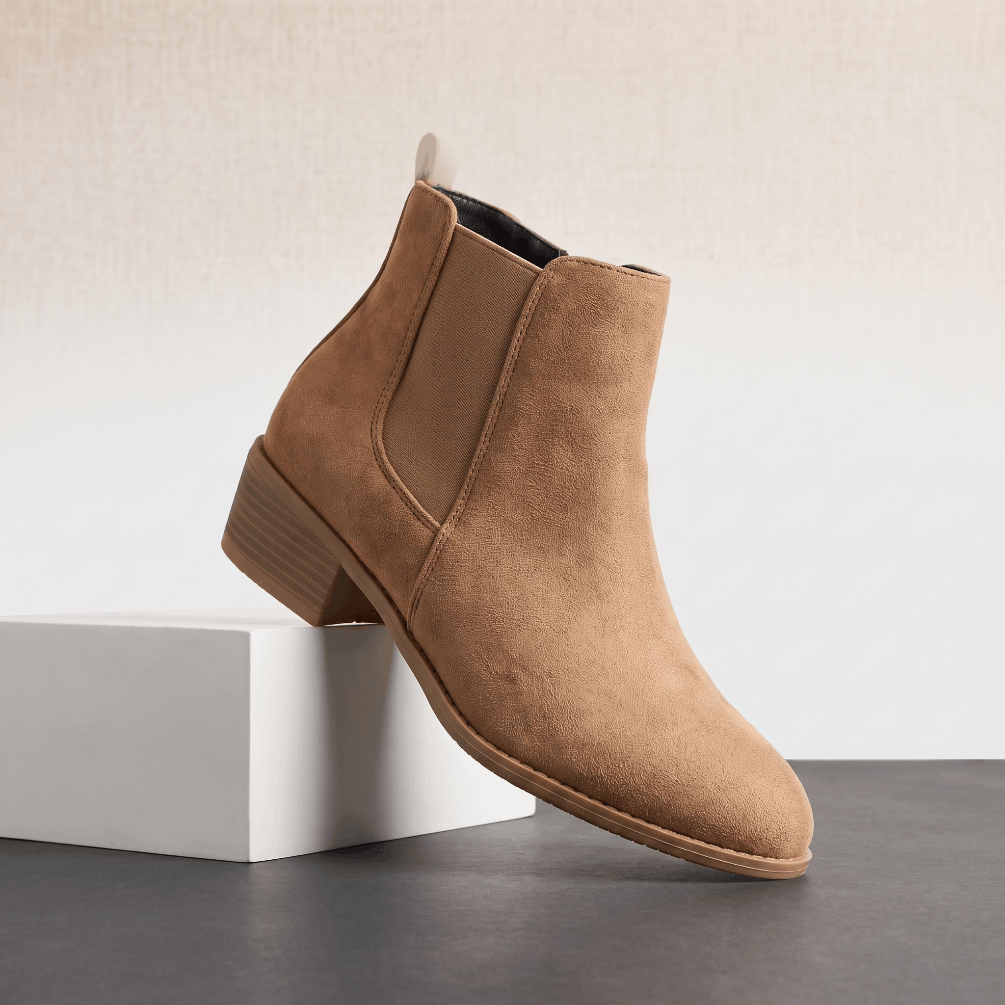 Beige vegan suede Chelsea boot displayed on a white pedestal.