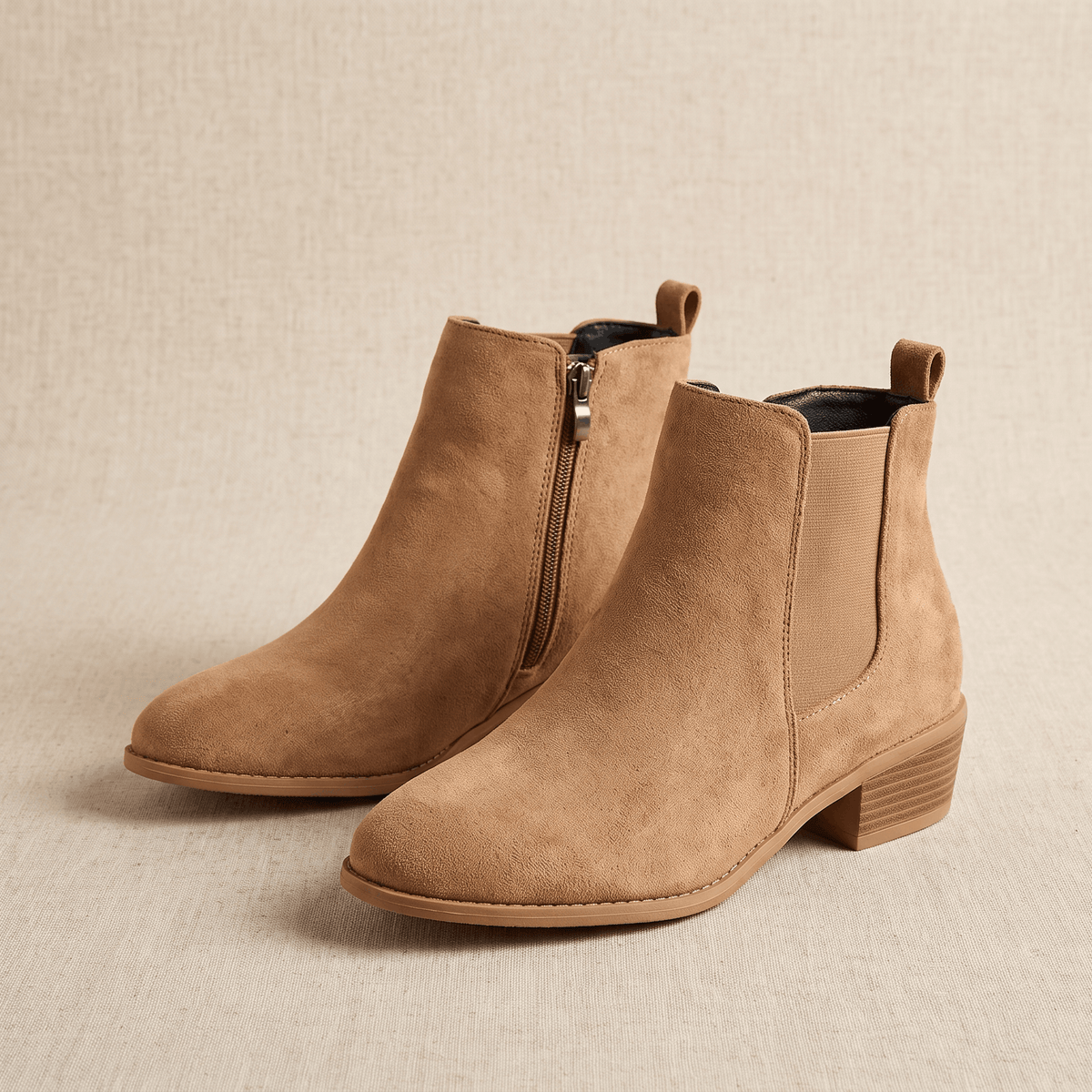 Pair of beige vegan suede Chelsea boots on a neutral background.